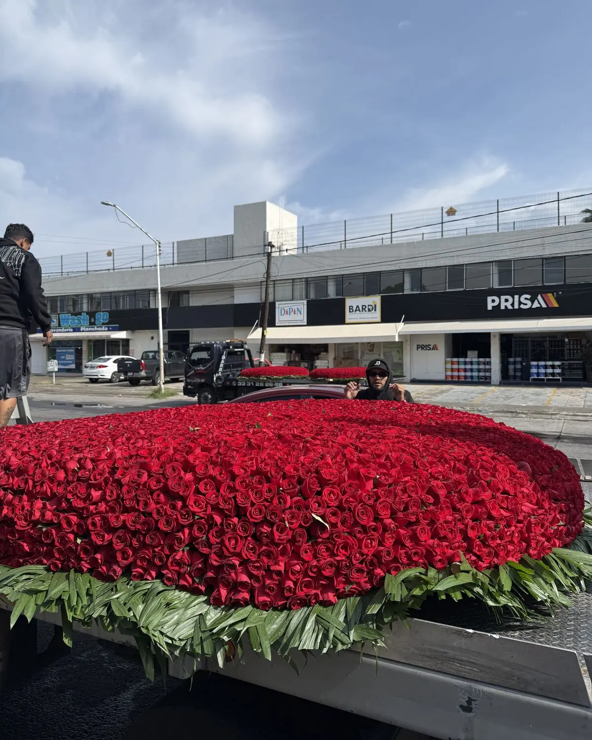 Corona de 5,000 rosas rojas acostada sobre la plataforma de una grúa, lista para el traslado
